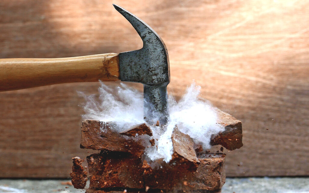 Image of bricks destroyed by a hammer.