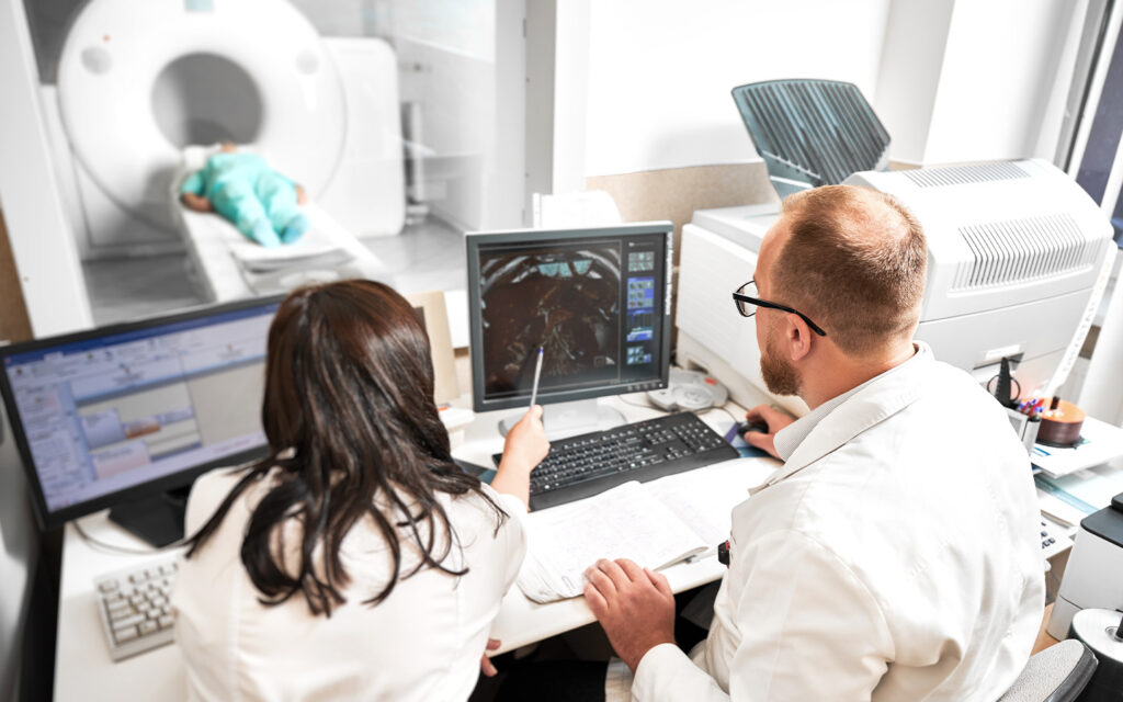 Image of two medical professionals looking at a CT image.